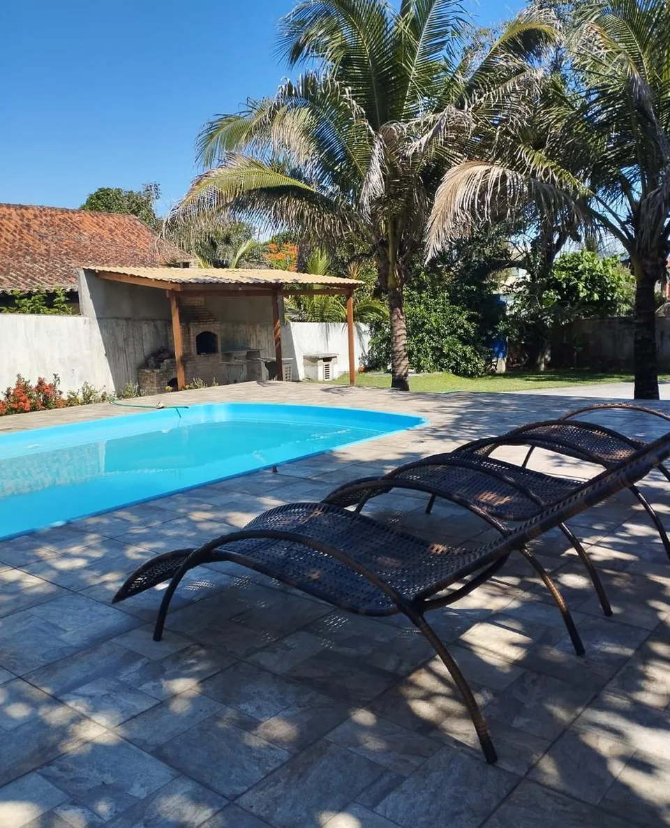 Piscina de sete metros da Casa de Praia Saquarema com espreguiçadeiras na borda