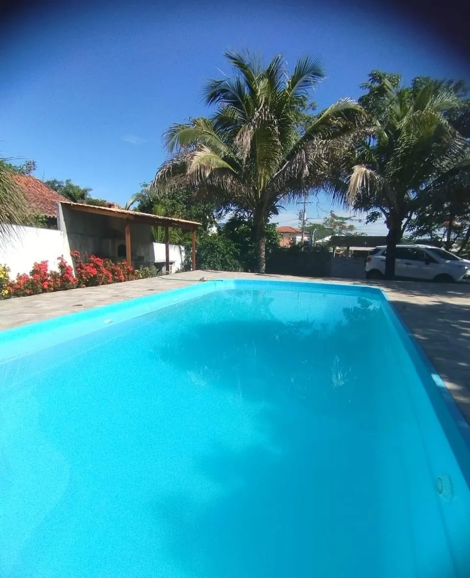 Piscina da Casa de Praia Saquarema vista de cima, entre palmeiras
